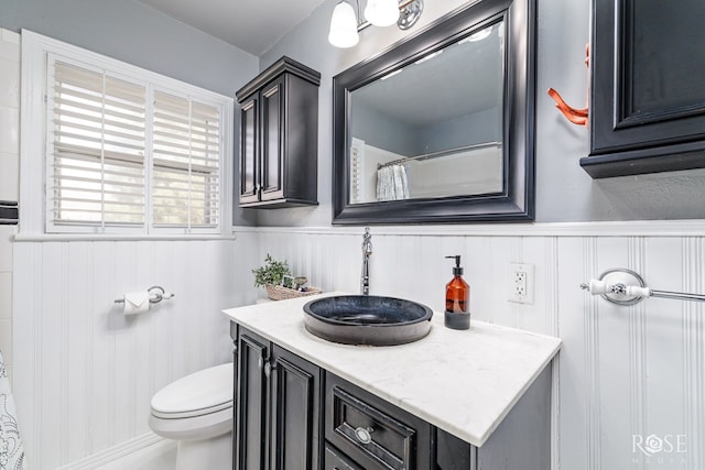 bathroom featuring a wainscoted wall, vanity, and toilet