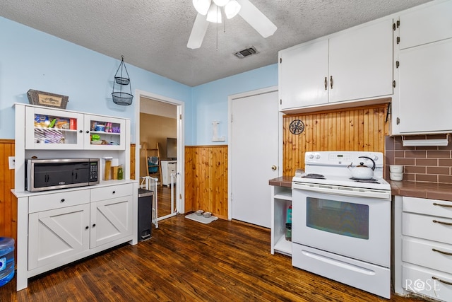 kitchen featuring visible vents, white cabinets, wainscoting, dark wood-style floors, and white electric range