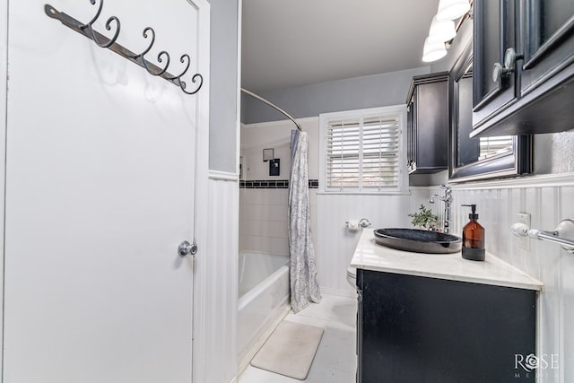 bathroom featuring a wainscoted wall, tile patterned floors, shower / tub combo with curtain, and vanity