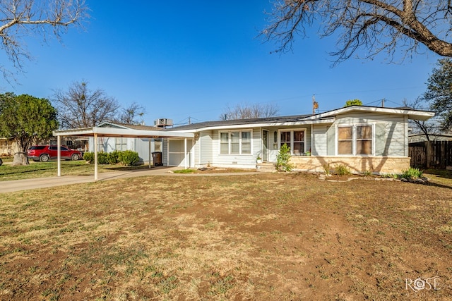 ranch-style home with concrete driveway, a front lawn, fence, and an attached carport