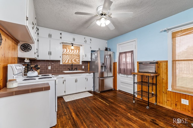 kitchen featuring white range with electric cooktop, stainless steel fridge with ice dispenser, tile countertops, dark wood-type flooring, and a sink