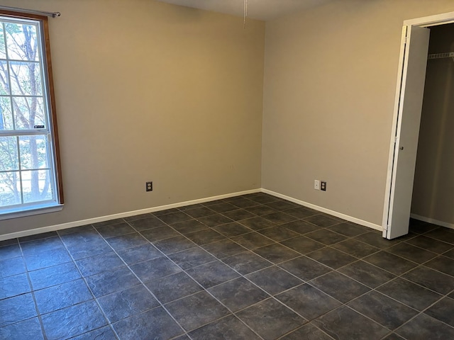 interior space with dark tile patterned flooring and multiple windows