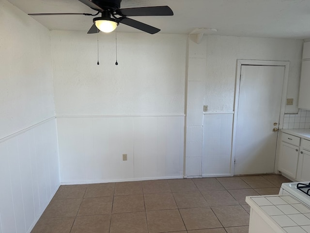 empty room featuring light tile patterned floors and ceiling fan