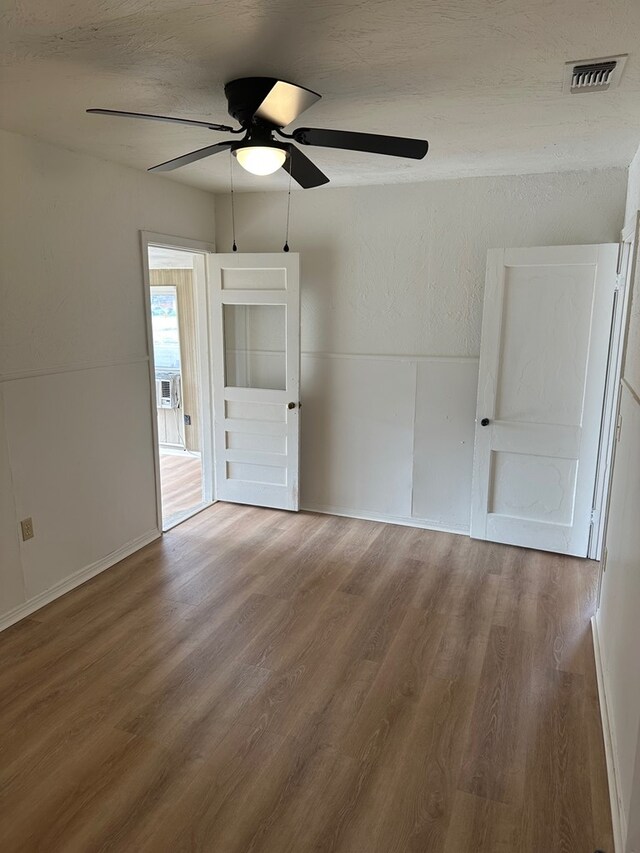 empty room with ceiling fan and wood-type flooring