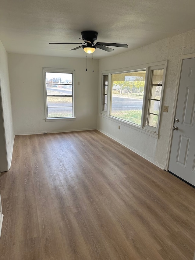 unfurnished room with ceiling fan and light wood-type flooring