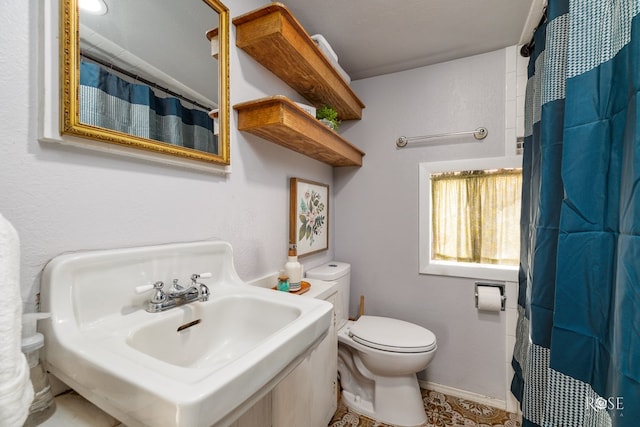 bathroom featuring walk in shower, sink, and toilet