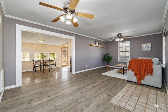 living room with wood-type flooring, cooling unit, ornamental molding, ceiling fan, and a textured ceiling