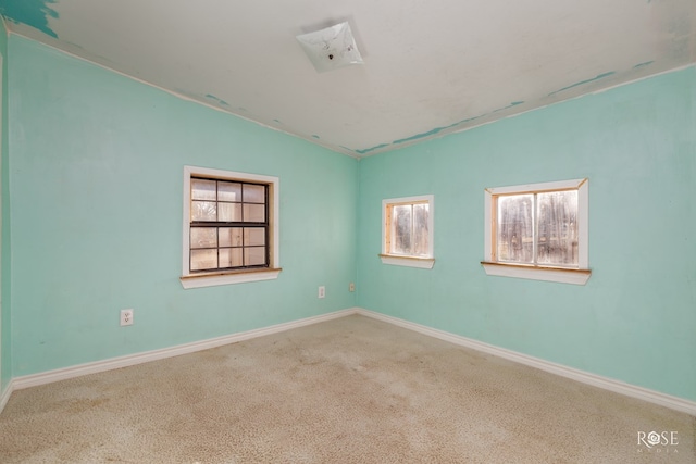 carpeted empty room featuring vaulted ceiling