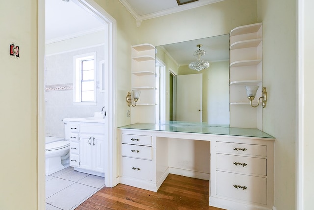 bathroom featuring toilet, ornamental molding, wood finished floors, and vanity