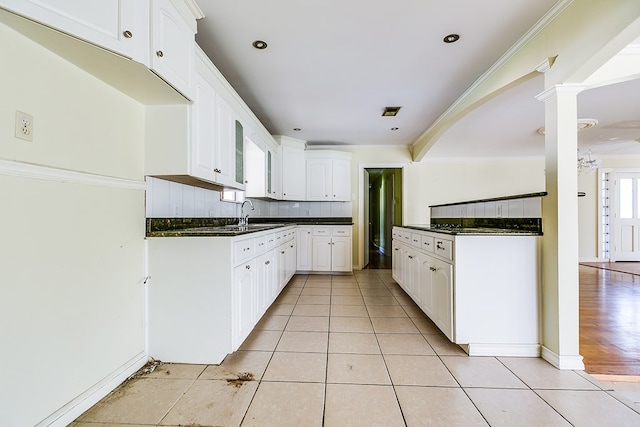 kitchen featuring dark countertops, crown molding, and light tile patterned floors