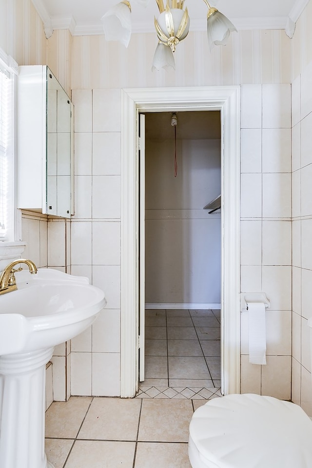 half bath featuring a wealth of natural light, tile walls, crown molding, and tile patterned floors