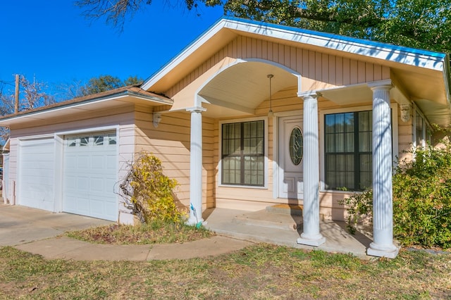 doorway to property with a garage and a porch