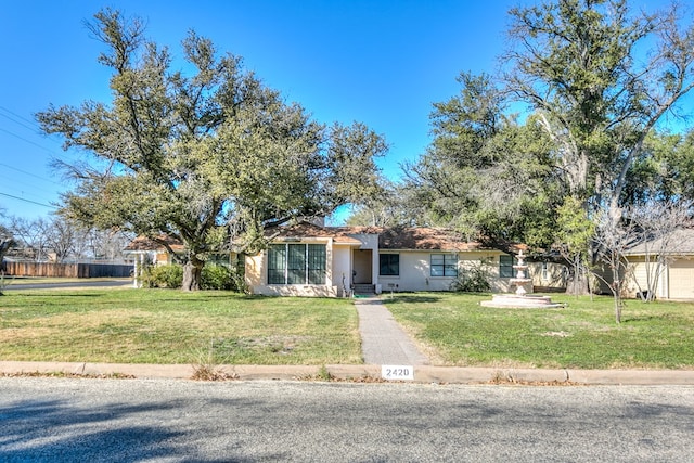 ranch-style house featuring a front lawn and stucco siding