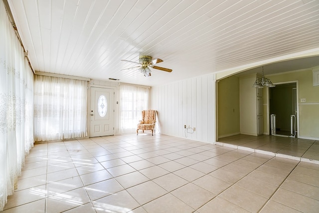 interior space with a ceiling fan, arched walkways, visible vents, and light tile patterned floors