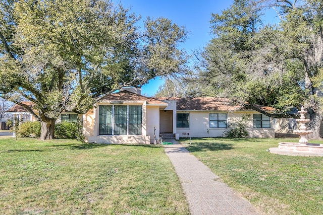 ranch-style house featuring a front lawn and stucco siding