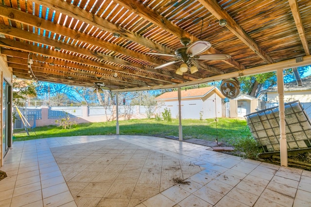 view of patio / terrace featuring an outbuilding, fence, a ceiling fan, and a pergola