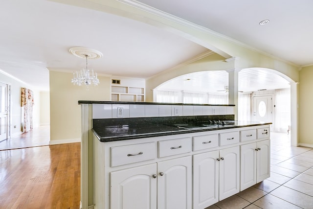 kitchen featuring pendant lighting, light wood finished floors, ornamental molding, white cabinetry, and ceiling fan