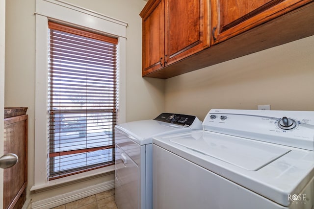 clothes washing area featuring separate washer and dryer and cabinets