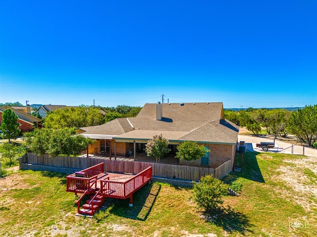 rear view of property with a wooden deck and a yard