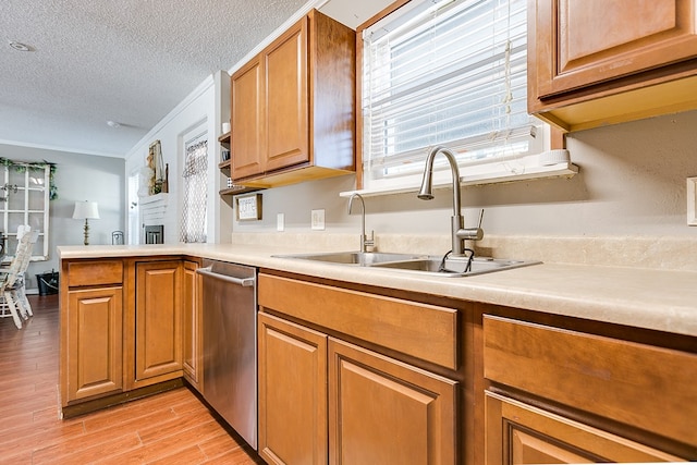 kitchen with sink, crown molding, light hardwood / wood-style flooring, dishwasher, and a textured ceiling