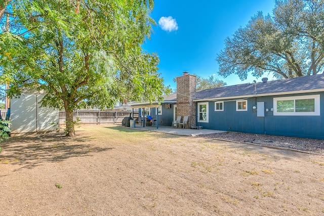 rear view of house featuring a yard and a patio area