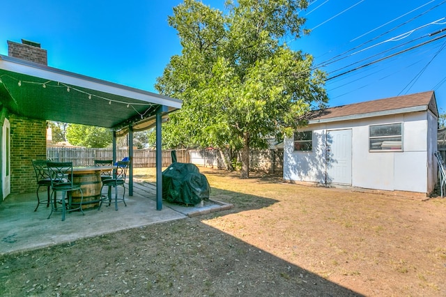 view of yard with exterior bar, an outdoor structure, and a patio area