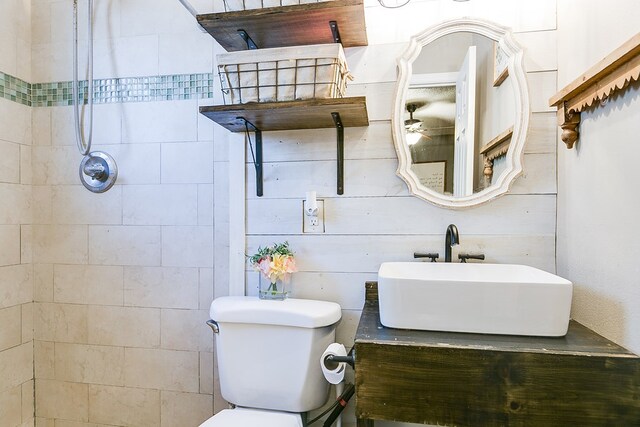 bathroom with vanity, toilet, and a tile shower