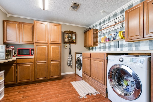 washroom featuring washer / clothes dryer, ornamental molding, and a textured ceiling