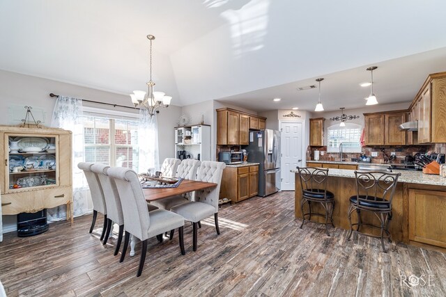4137 Sedona Trl, San Angelo, TX 76904 - dining area featuring a chandelier, dark wood-style flooring, vaulted ceiling, and recessed lighting