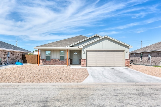 2822 Joshua St, San Angelo, TX 76905 - view of front facade with a garage, brick siding, board and batten siding, and driveway