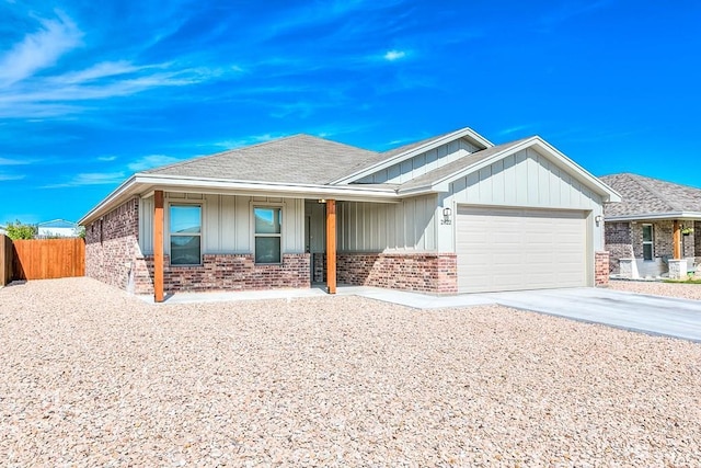 2822 Joshua St, San Angelo, TX 76905 - view of front of property with brick siding, a garage, driveway, a porch, and board and batten siding