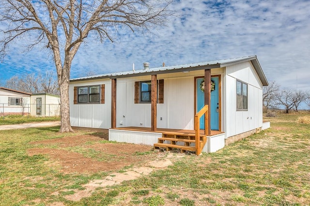 view of front of home with metal roof and a front yard