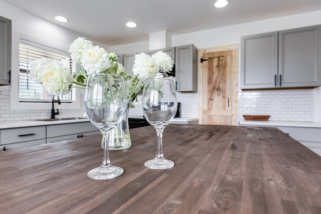 interior details featuring tasteful backsplash, a sink, and recessed lighting