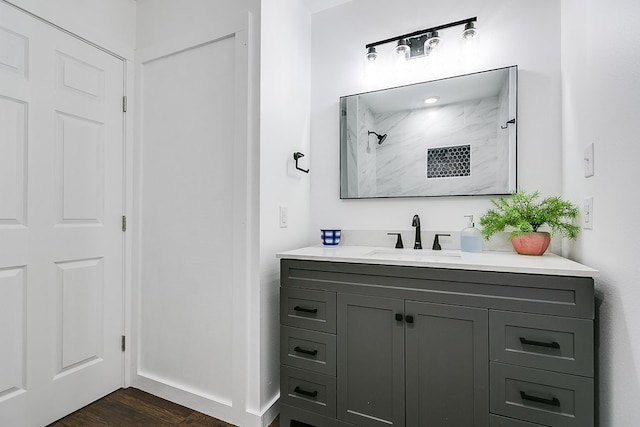 bathroom featuring walk in shower, vanity, and wood finished floors