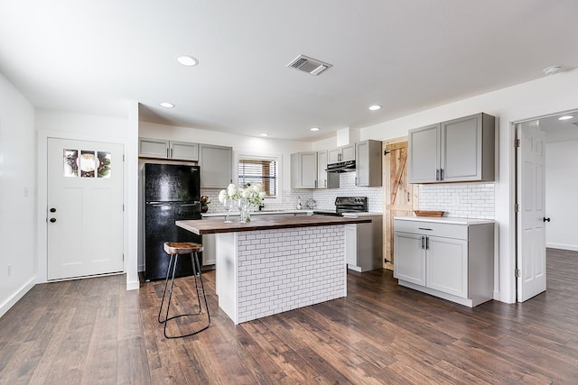 kitchen featuring freestanding refrigerator, gray cabinets, visible vents, and wood counters