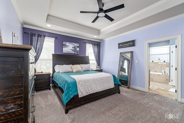 bedroom with ensuite bathroom, crown molding, ceiling fan, a tray ceiling, and light colored carpet