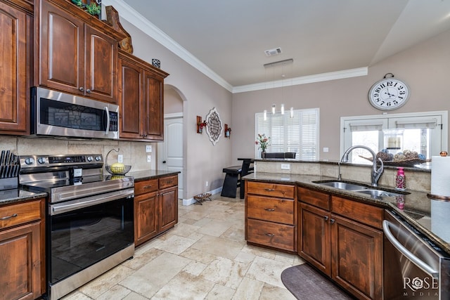 kitchen with sink, crown molding, appliances with stainless steel finishes, dark stone countertops, and tasteful backsplash