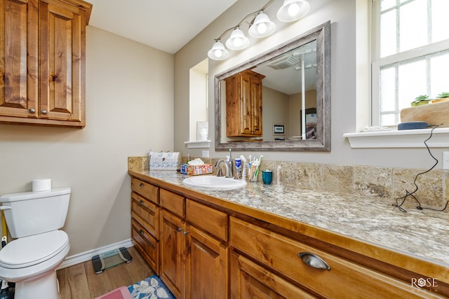 bathroom featuring vanity, toilet, and hardwood / wood-style floors