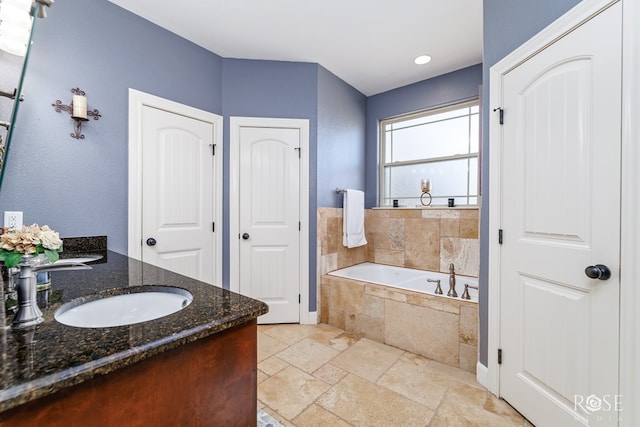 bathroom with a relaxing tiled tub and vanity