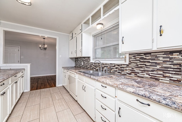 2501 Tcu Ave, San Angelo, TX 76904 - kitchen featuring white dishwasher, decorative backsplash, a chandelier, white cabinetry, and crown molding