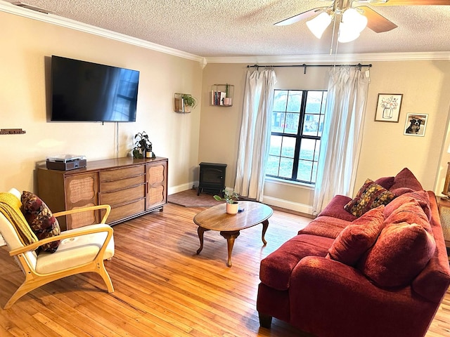 living room featuring ornamental molding, a wood stove, a textured ceiling, and light hardwood / wood-style flooring