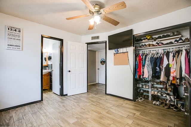 119 Van Zandt St, San Angelo, TX 76905 - bedroom featuring light wood finished floors, a closet, a ceiling fan, ensuite bathroom, and baseboards