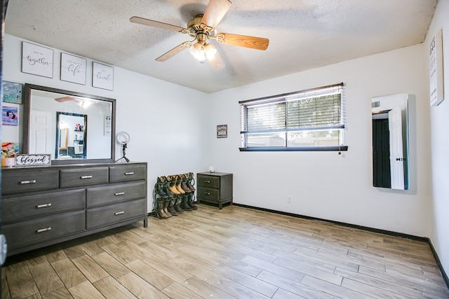119 Van Zandt St, San Angelo, TX 76905 - bedroom featuring light wood finished floors, a textured ceiling, a ceiling fan, and baseboards