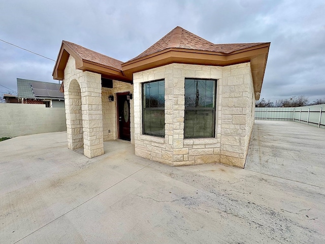 2110 Shelton St, San Angelo, TX 76903 - entrance to property with a patio, stone siding, and a shingled roof