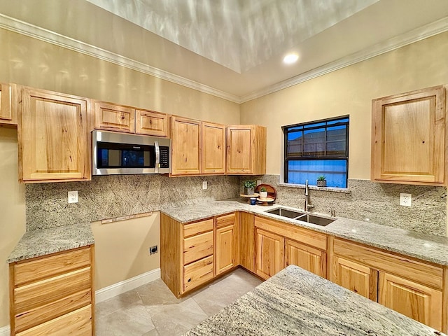 2110 Shelton St, San Angelo, TX 76903 - kitchen with stainless steel microwave, crown molding, light stone countertops, tasteful backsplash, and light brown cabinets