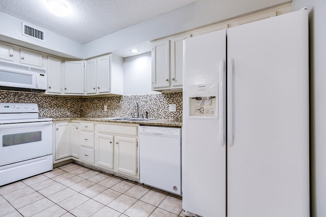 kitchen with white appliances, a sink, visible vents, white cabinets, and backsplash