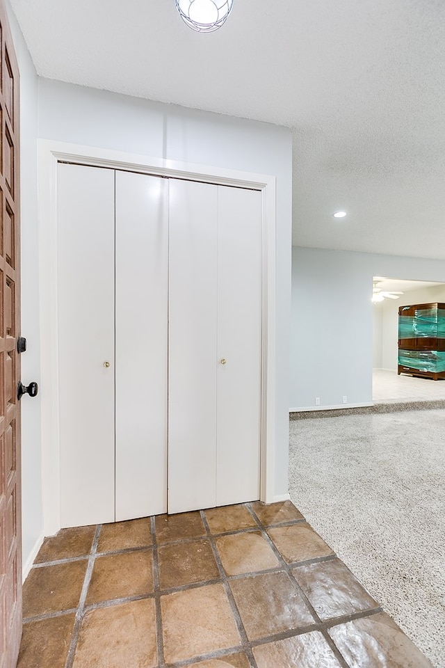 interior space with stone tile floors, a textured ceiling, and recessed lighting