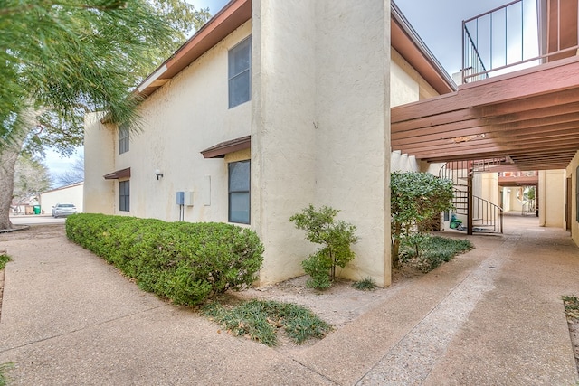 view of home's exterior with stairway and stucco siding