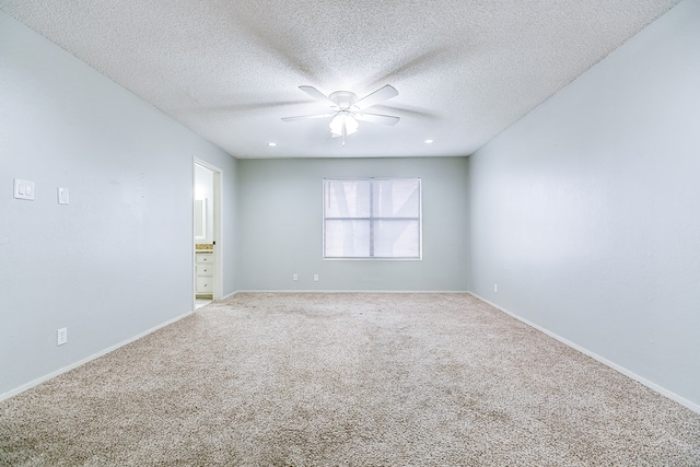 carpeted empty room featuring ceiling fan, a textured ceiling, and baseboards