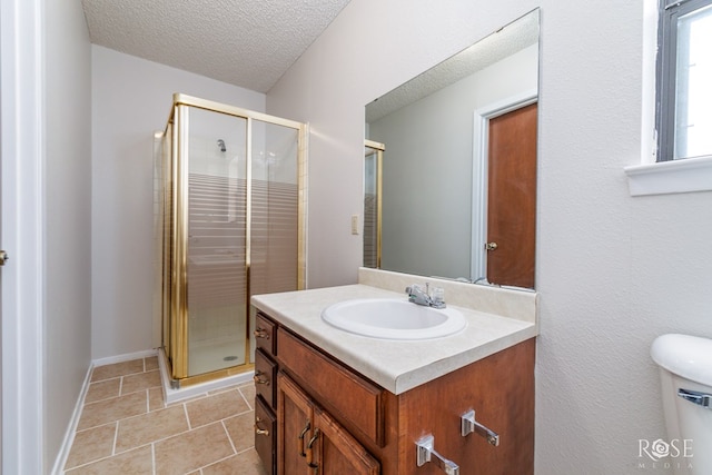full bathroom featuring vanity, toilet, a textured ceiling, tile patterned floors, and a stall shower